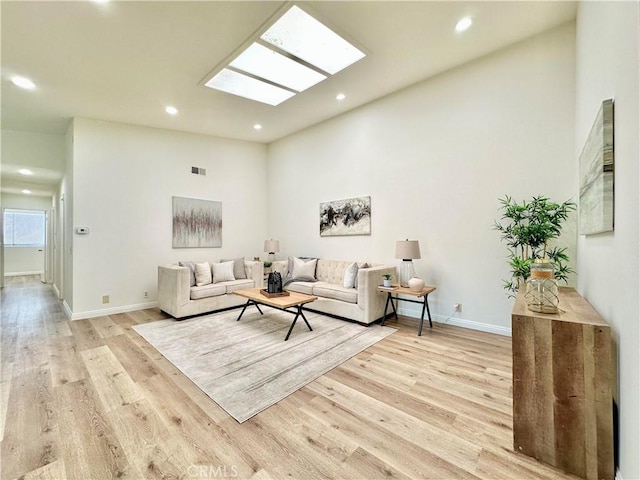 living area featuring visible vents, baseboards, recessed lighting, and light wood-type flooring