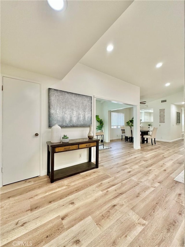 hall featuring light wood-type flooring, visible vents, and recessed lighting
