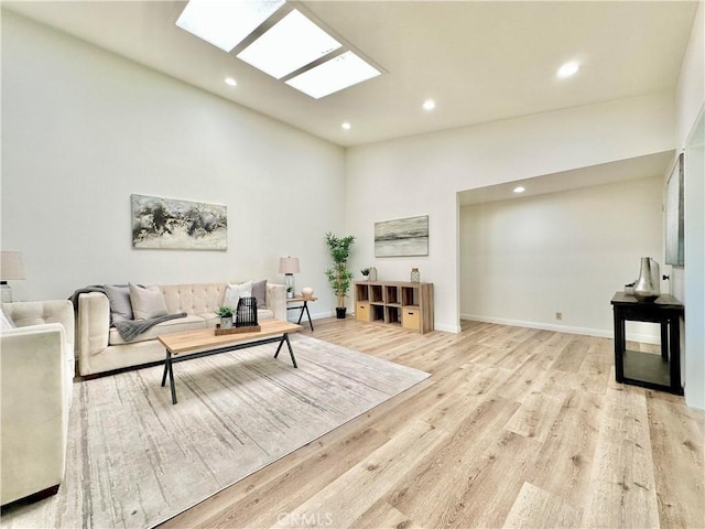 living area featuring light wood finished floors, baseboards, lofted ceiling, and recessed lighting