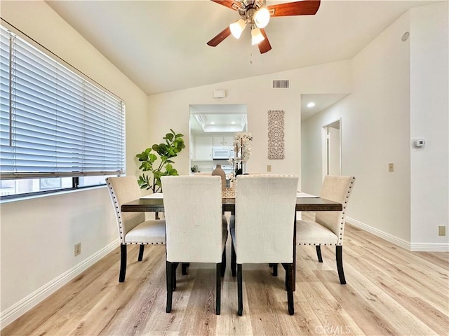 dining space with attic access, baseboards, light wood finished floors, ceiling fan, and visible vents