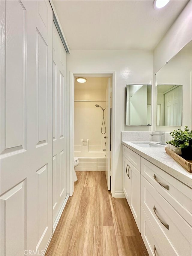 bathroom featuring bathing tub / shower combination, wood finished floors, toilet, and vanity