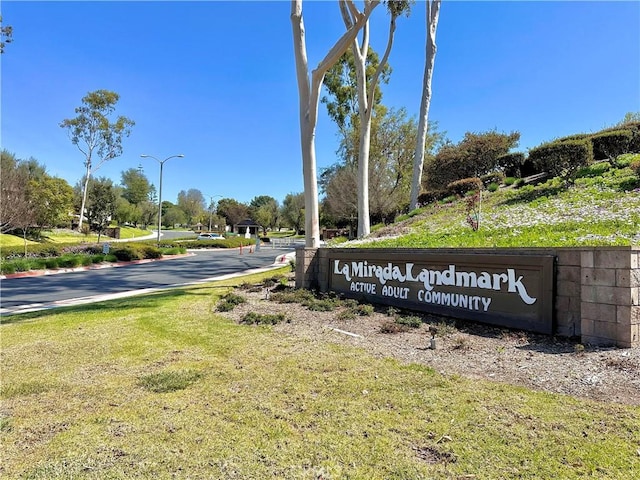 community / neighborhood sign featuring a yard