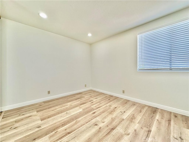 unfurnished room with baseboards, recessed lighting, and light wood finished floors