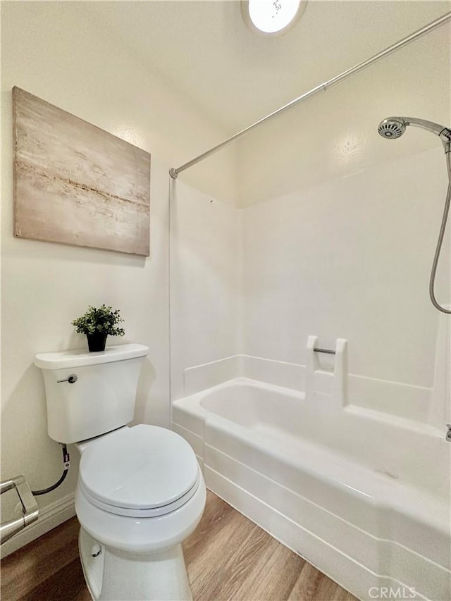 full bath featuring  shower combination, wood finished floors, and toilet