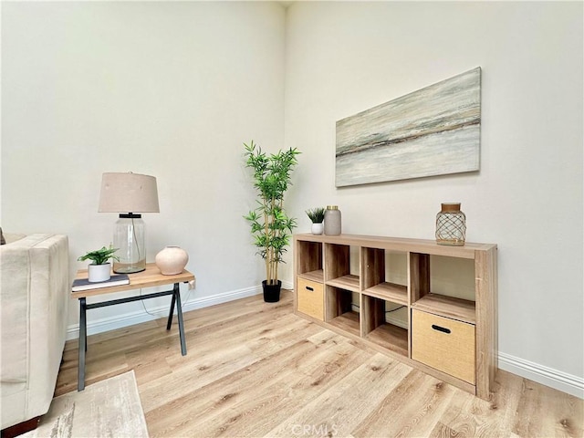 living area with baseboards and wood finished floors