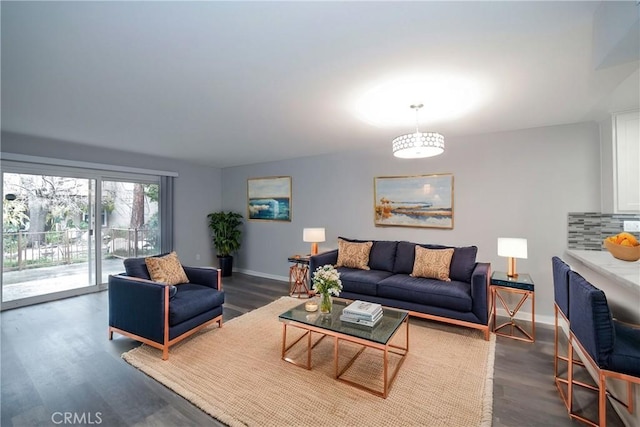 living room featuring dark wood-type flooring and baseboards