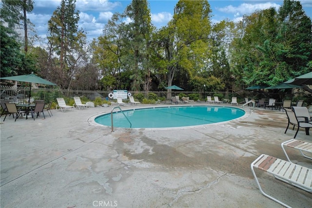 pool featuring a patio area and fence