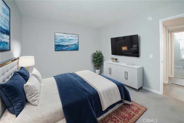 bedroom featuring baseboards and light colored carpet
