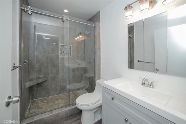 full bath featuring a stall shower, toilet, and vanity