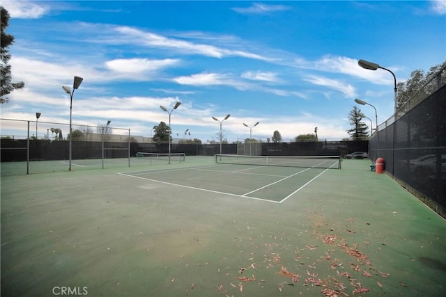 view of tennis court featuring fence
