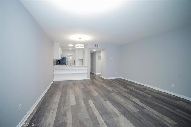 unfurnished living room with visible vents, baseboards, and dark wood finished floors