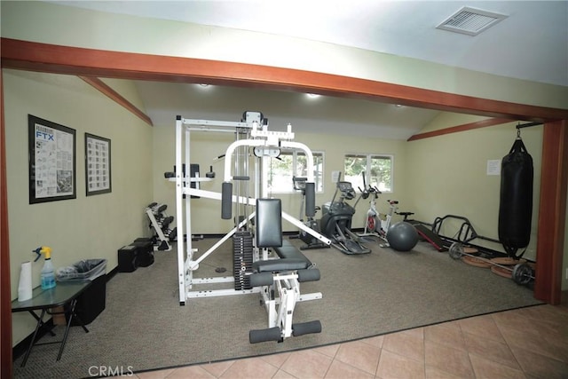 exercise room featuring tile patterned flooring, visible vents, lofted ceiling, and carpet floors