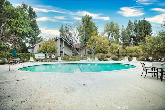 pool with a patio and fence
