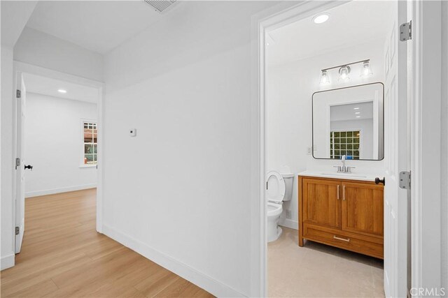 7116 Waring Ave, Los Angeles, CA 90046 - bathroom with vanity, wood finished floors, visible vents, baseboards, and toilet