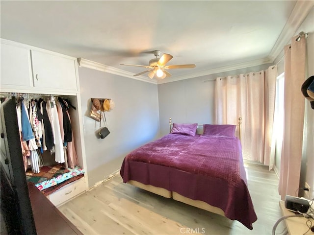 bedroom with a closet, a ceiling fan, light wood-type flooring, and crown molding
