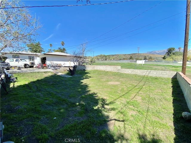 view of yard featuring a mountain view and fence