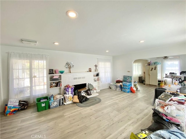 living area featuring a ceiling fan, recessed lighting, arched walkways, and wood finished floors