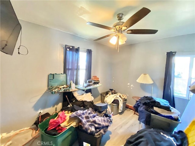 bedroom featuring multiple windows, ceiling fan, and wood finished floors