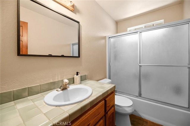 252 Riverside Ave, Sugarloaf, CA 92386 - full bathroom with toilet, vanity, a textured wall, and enclosed tub / shower combo