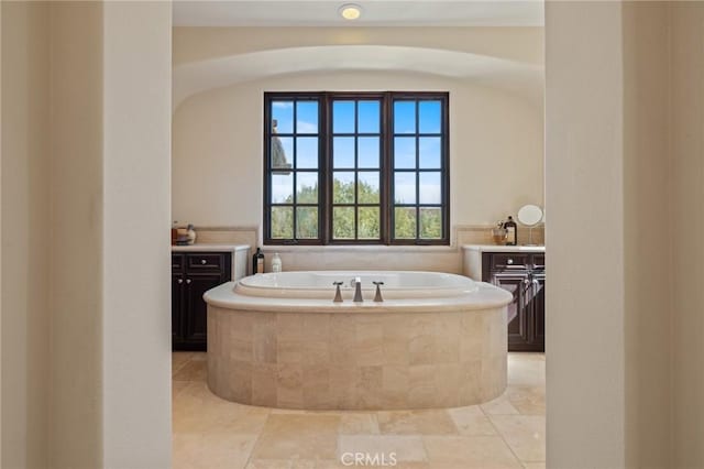 full bath featuring vanity and a garden tub