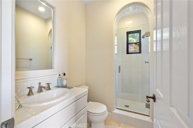bathroom featuring a shower stall, tile patterned floors, vanity, and toilet