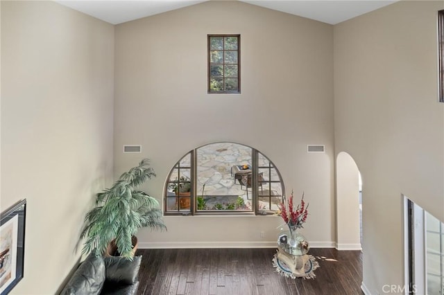 details featuring arched walkways, wood finished floors, baseboards, and visible vents