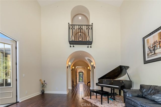 3 Observatory, Newport Coast, CA 92657 - living area with arched walkways, a high ceiling, wood finished floors, and baseboards