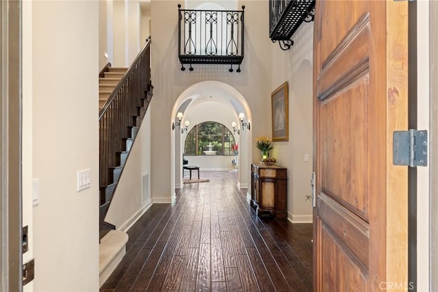 3 Observatory, Newport Coast, CA 92657 - entrance foyer featuring arched walkways, stairway, dark wood-style floors, a high ceiling, and baseboards
