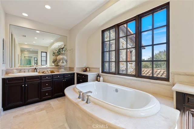 bathroom with a bath, vanity, visible vents, and recessed lighting