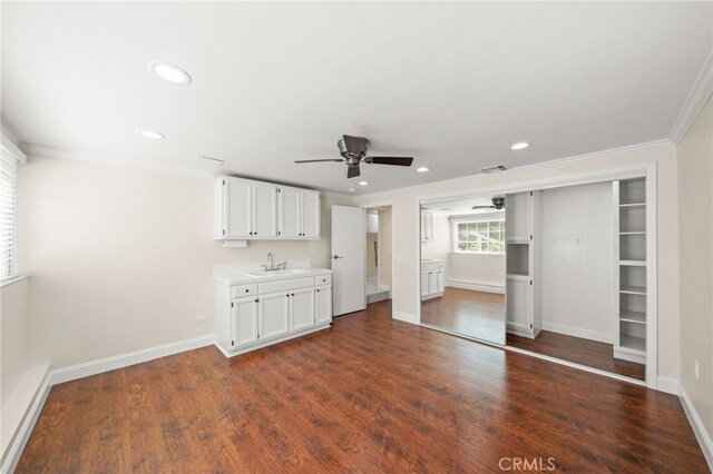 unfurnished bedroom with crown molding, dark wood finished floors, visible vents, recessed lighting, and a sink