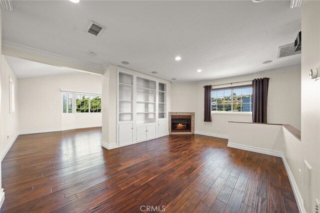 unfurnished living room featuring visible vents, baseboards, plenty of natural light, and hardwood / wood-style floors