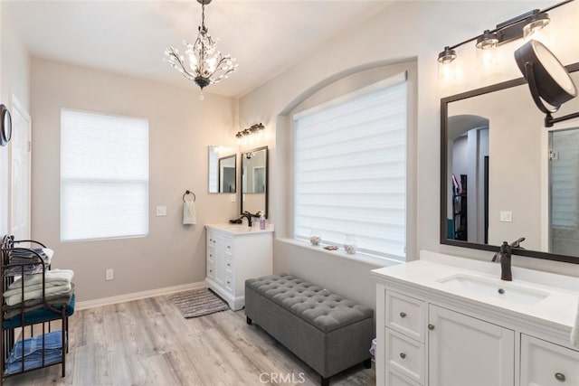 2845 Keystone Cir, Corona, CA 92882 - full bathroom featuring two vanities, wood finished floors, a chandelier, and baseboards