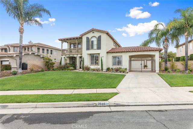 2845 Keystone Cir, Corona, CA 92882 - mediterranean / spanish house featuring a balcony, a tile roof, concrete driveway, stucco siding, and a gate