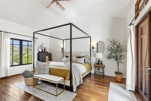 bedroom featuring hardwood / wood-style floors, vaulted ceiling, and a ceiling fan