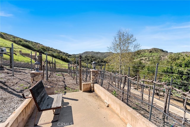 view of patio / terrace featuring fence, a rural view, and a mountain view