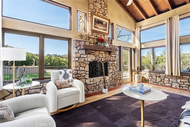 living area with high vaulted ceiling, a fireplace, wood finished floors, beam ceiling, and wood ceiling