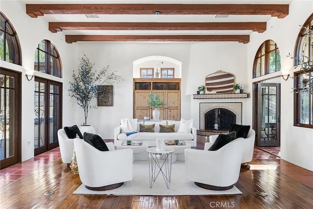living area featuring wood-type flooring, a fireplace, french doors, and a healthy amount of sunlight