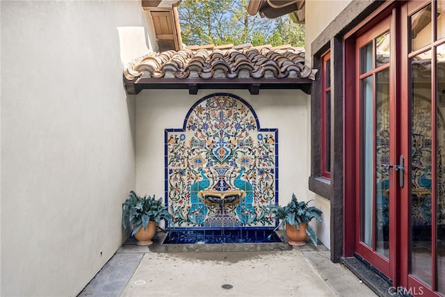 entrance to property with stucco siding and a tiled roof