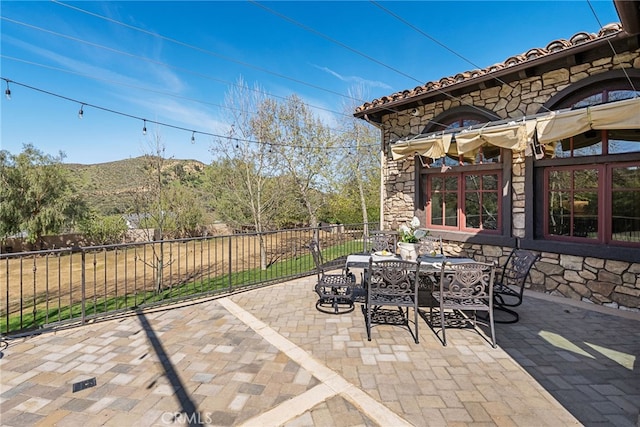 view of patio featuring outdoor dining area and fence