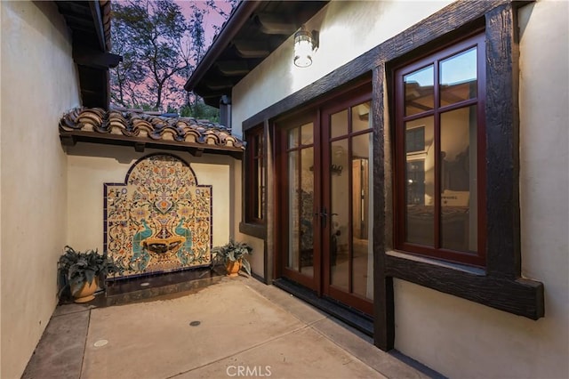 entrance to property featuring french doors and stucco siding