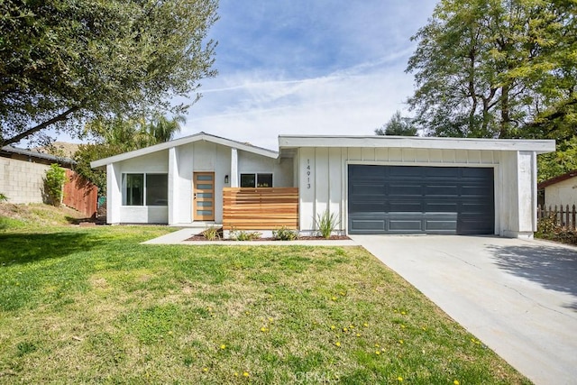 view of front of house featuring an attached garage, driveway, a front yard, and fence