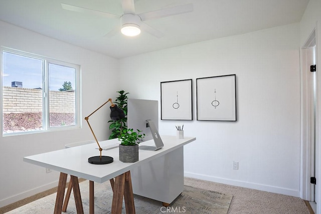 carpeted office with baseboards and ceiling fan
