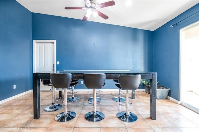 dining area featuring tile patterned flooring, a ceiling fan, and baseboards