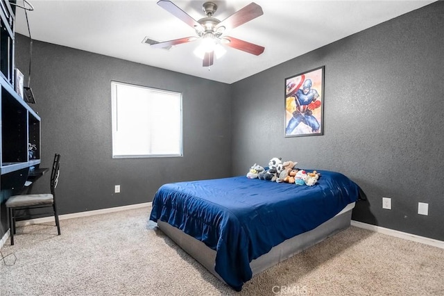 carpeted bedroom featuring a textured wall, baseboards, and ceiling fan