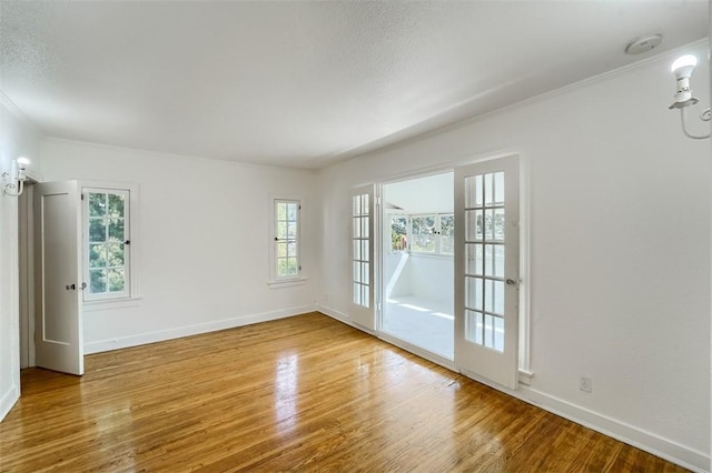 unfurnished room with plenty of natural light, baseboards, and wood finished floors