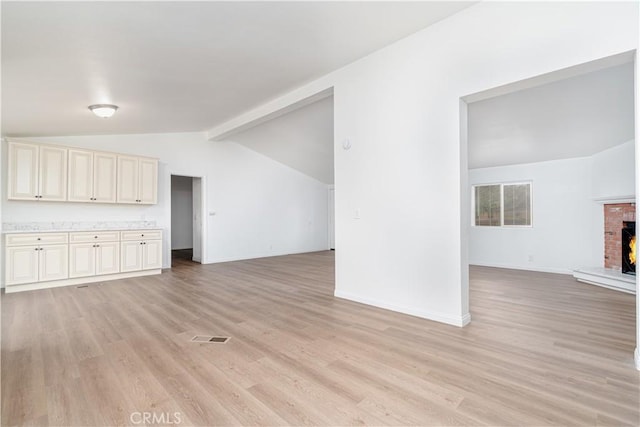 1357 Mount Shasta St, Perris, CA 92570 - unfurnished living room with light wood-style floors, baseboards, and a brick fireplace