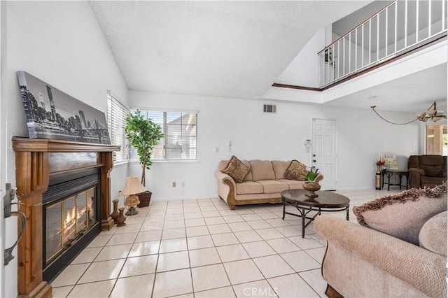 42851 Lemonwood Dr, Lancaster, CA 93536 - living room featuring plenty of natural light, a glass covered fireplace, light tile patterned floors, and vaulted ceiling