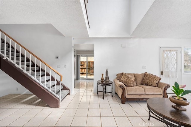 42851 Lemonwood Dr, Lancaster, CA 93536 - living area featuring light tile patterned flooring, stairs, and a textured ceiling