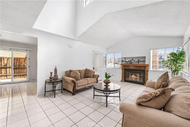 42851 Lemonwood Dr, Lancaster, CA 93536 - living area featuring plenty of natural light, light tile patterned floors, lofted ceiling, and a glass covered fireplace