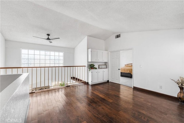 42851 Lemonwood Dr, Lancaster, CA 93536 - empty room with a ceiling fan, dark wood-style floors, a textured ceiling, and lofted ceiling